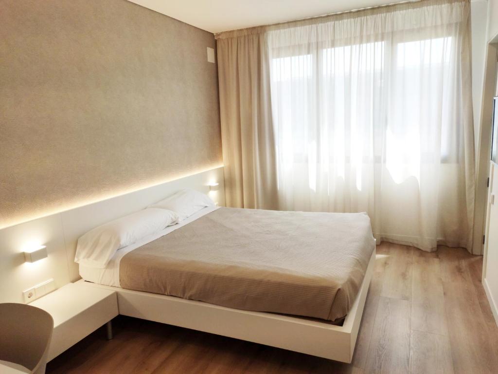 Habitación pequeña con cama y ventana en Hotel Las Terrazas, en Burgos