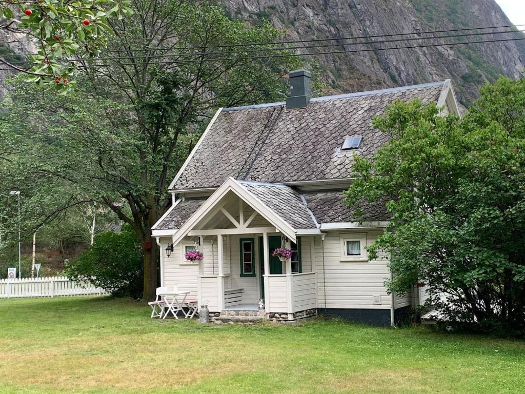a white house with a table and chairs in a yard at Aobrio Holidayhouse, old farmhouse close to Flåm in Lærdalsøyri
