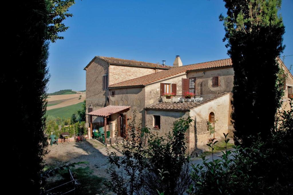 an image of a building in a vineyard at Agriturismo Podere Olivello in Val d'Orcia in Montalcino