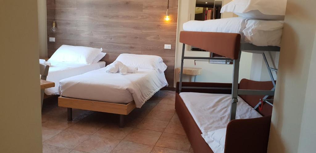 ボルディゲーラにあるHotel Raphaelのベッド2台と二段ベッド2組が備わる客室です。