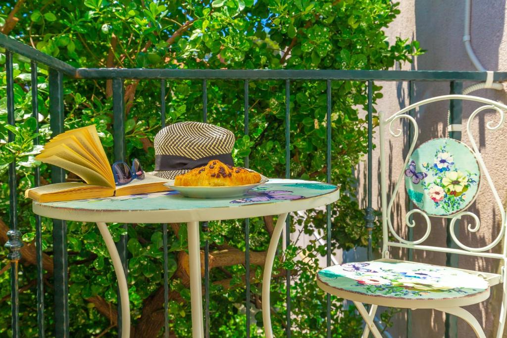 einen Tisch mit einem Hut und einem Teller Essen drauf. in der Unterkunft Studio Amy in Dubrovnik
