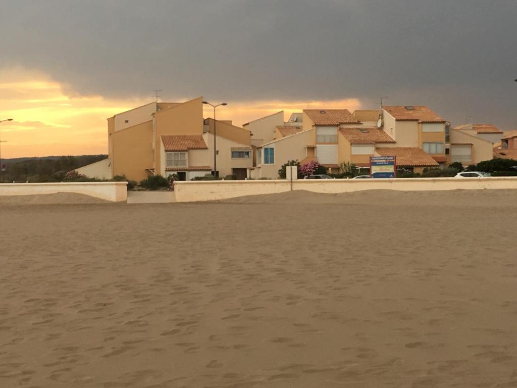 a view of a beach with houses in the background at Les balcons de la Medtirrannée front de mer in Narbonne-Plage