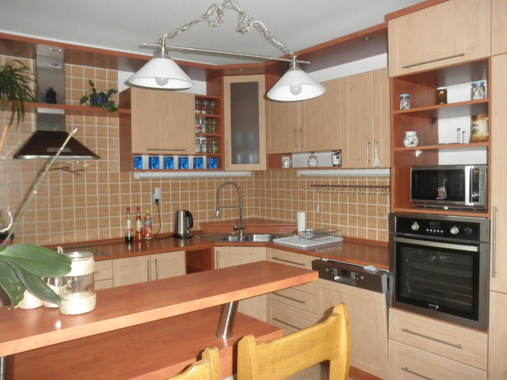 eine Küche mit Holzschränken und einer hölzernen Arbeitsplatte in der Unterkunft PENZION VLASTA in Zlín