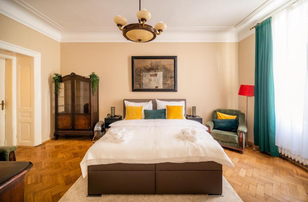 a bedroom with a large bed and a chandelier at Luxurious Kafka family apt in Old Town in Prague