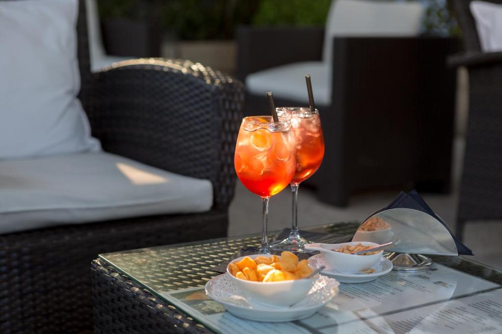 a table with two wine glasses and a bowl of fruit at Hotel Cristina in Naples