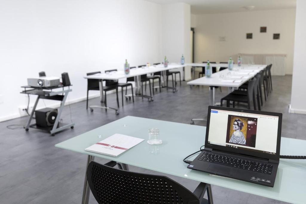 a laptop computer sitting on a table in a classroom at Hotel Cristina in Naples