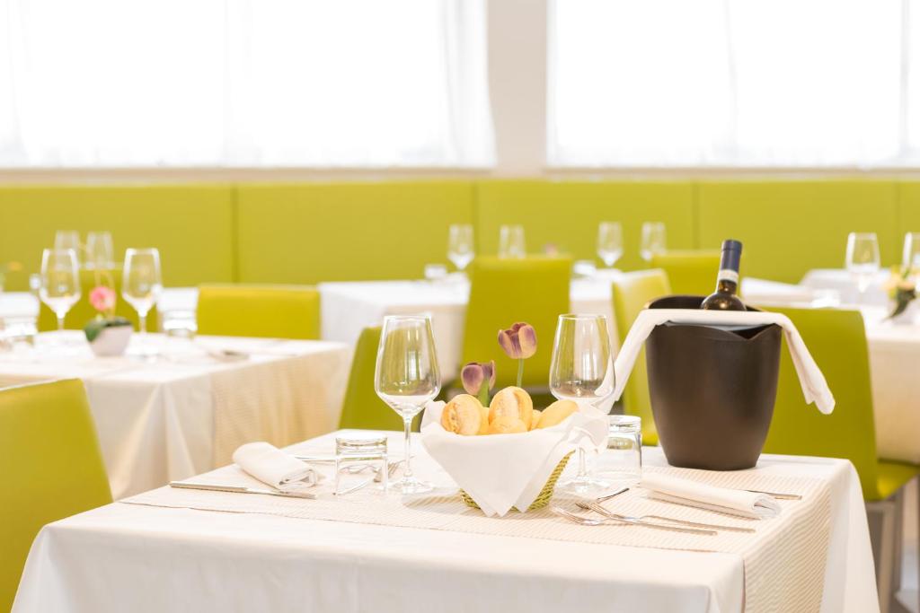 a restaurant with white tables and wine glasses at Hotel Cristina in Naples