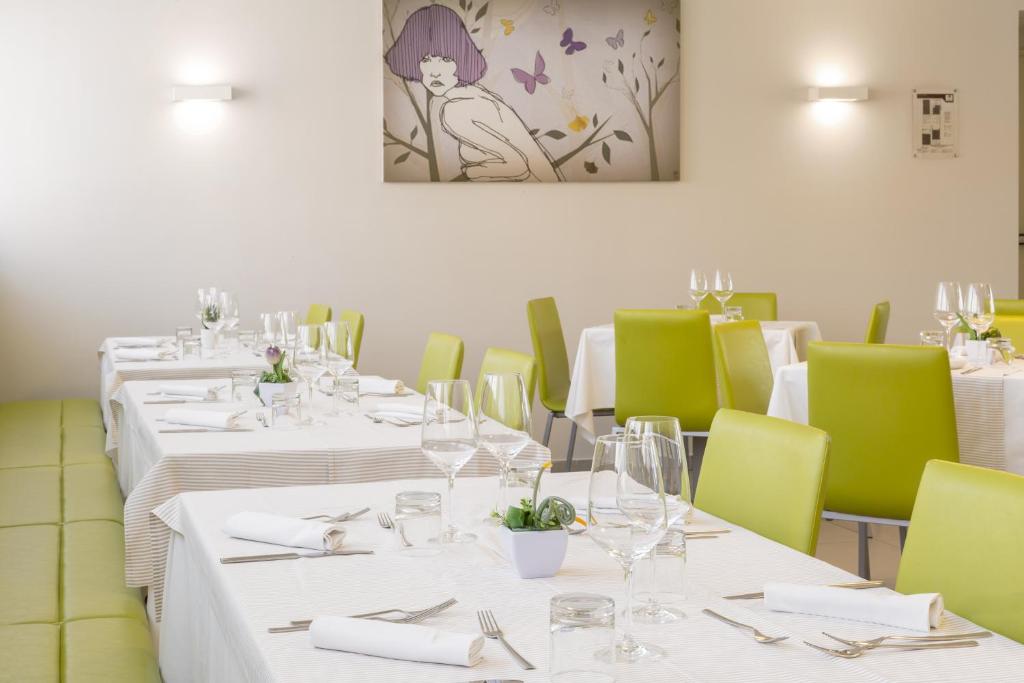 a dining room with white tables and green chairs at Hotel Cristina in Naples