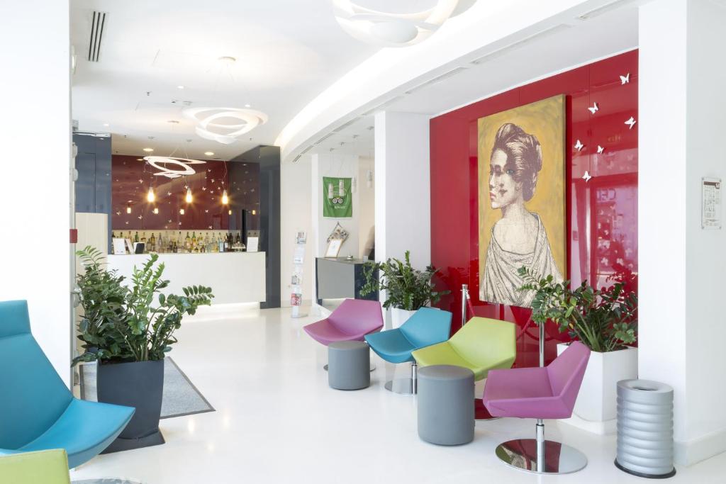 a lobby with colorful chairs and a painting at Hotel Cristina in Naples