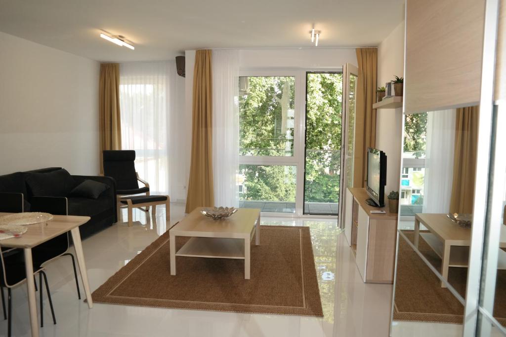 un soggiorno con divano e tavolo di Holiday Apartman with Free Parking a Győr