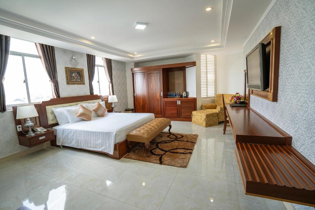 Duc Long Gia Lai Hotels & Apartment في بلاي كو: غرفة نوم بسرير واريكة وتلفزيون
