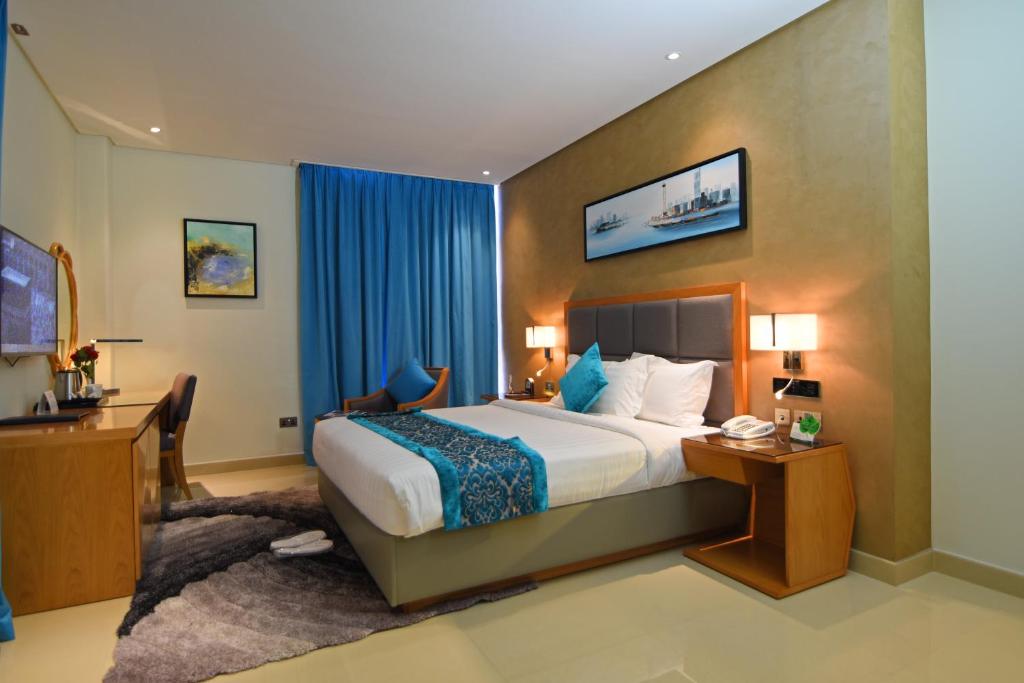 Habitación de hotel con cama y escritorio en Meshal Hotel, en Manama