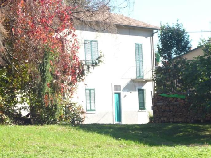 una casa blanca con persianas verdes y un árbol en IL FAGGIO ROSSO, en Missaglia
