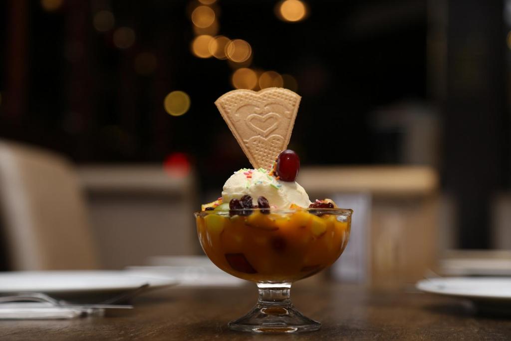 a dessert with ice cream and a cherry on a table at Casuarina Tree in Mitcham