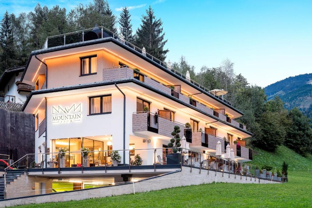 Un grand bâtiment blanc avec de nombreuses fenêtres dans l'établissement Mountain Resort M&M, à Finkenberg