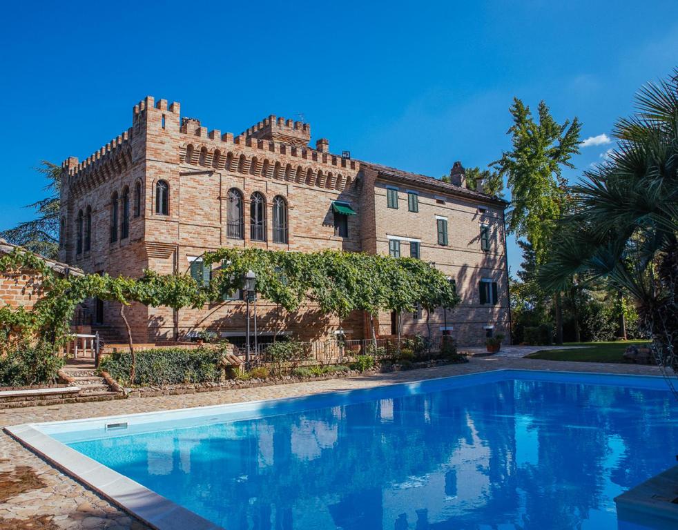 a house with a swimming pool in front of a building at Villa De Castelletta Relais in Rapagnano