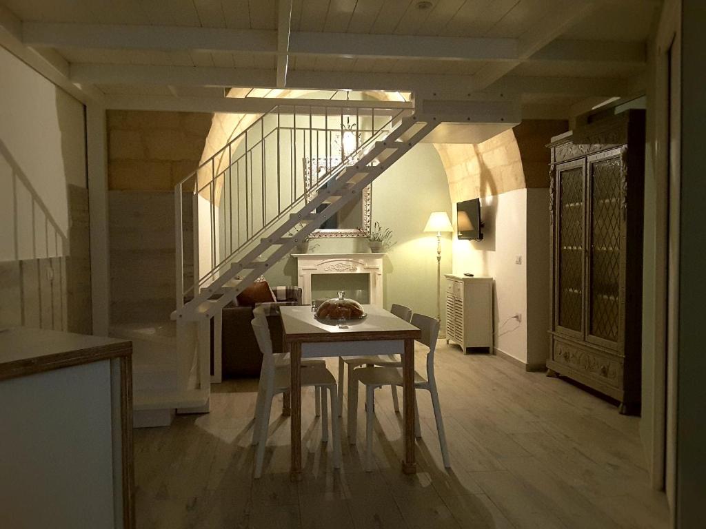 馬泰拉的住宿－SASSO BIANCO，一间带桌子和楼梯的用餐室