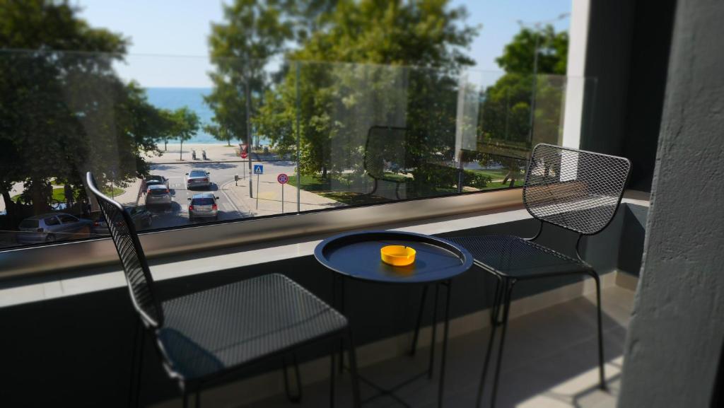 balcón con mesa y sillas y vistas a la calle en H&M Hotel, en Vlorë