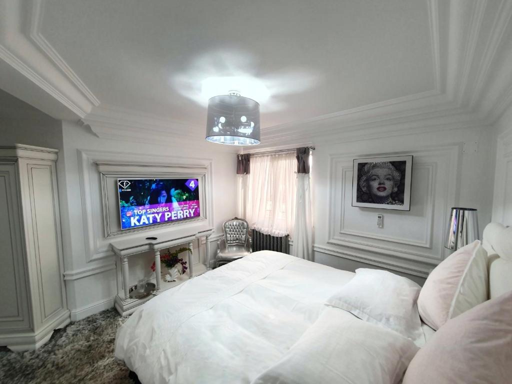 a bedroom with a white bed and a tv at President in Ploieşti