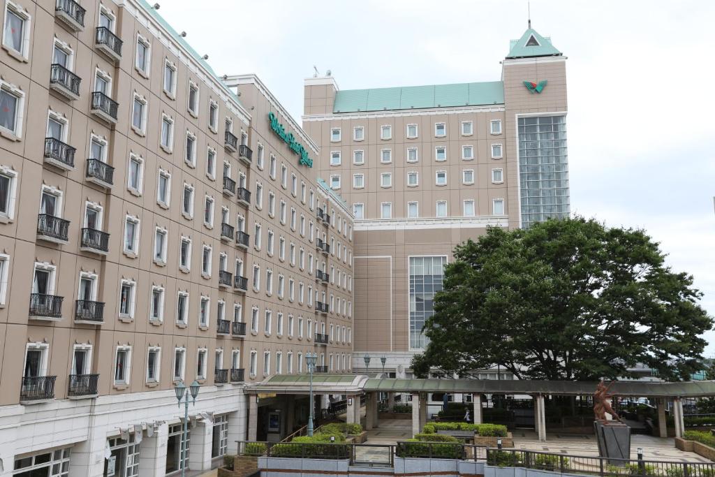 um grande edifício com uma torre de relógio em frente em Wishton Hotel Yukari em Sakura