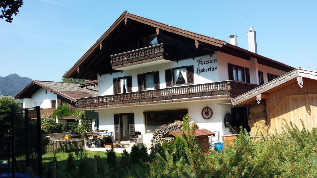 ein großes Haus mit Balkon darüber in der Unterkunft Wellness Pension Hubertus in Marquartstein