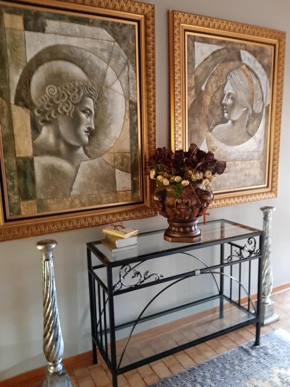 un tavolo con un vaso accanto a un dipinto di Fochville Guesthouse a Fochville