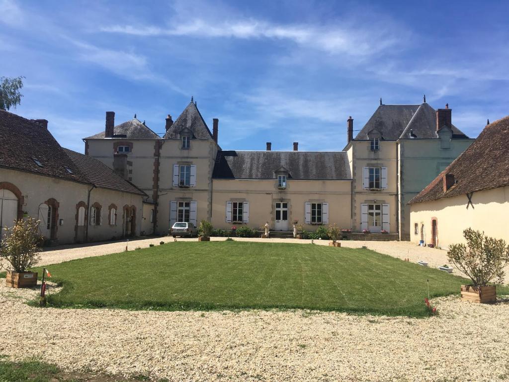 un grand château avec une grande pelouse devant lui dans l'établissement CHATEAU DE CHAVANNES, à Tresnay