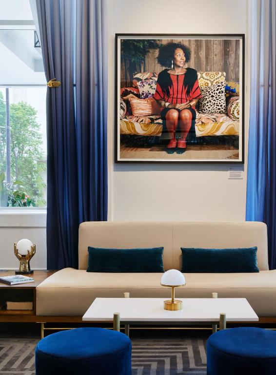 a living room with a couch and a painting on the wall at Saint Kate - The Arts Hotel in Milwaukee