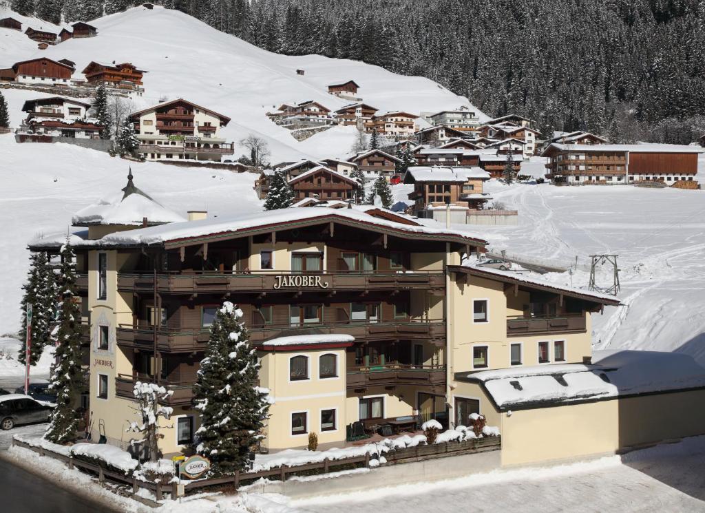 um edifício com neve no topo de uma montanha em Hotel-Garni Jakober em Tux