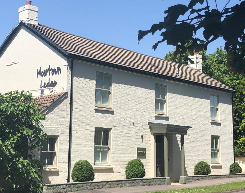 un edificio blanco con un cartel. en Moortown Lodge B&B en Ringwood