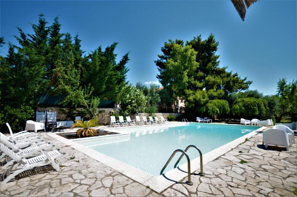 einem Pool mit Liegestühlen und einem Resort in der Unterkunft Signor Cesare Agrobistrot B&B in San Giovanni Rotondo