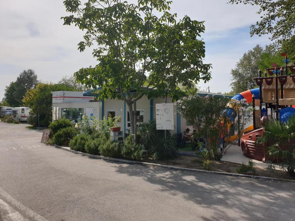 Una gasolinera con un árbol delante. en Campeggio Don Bosco en Lido di Jesolo