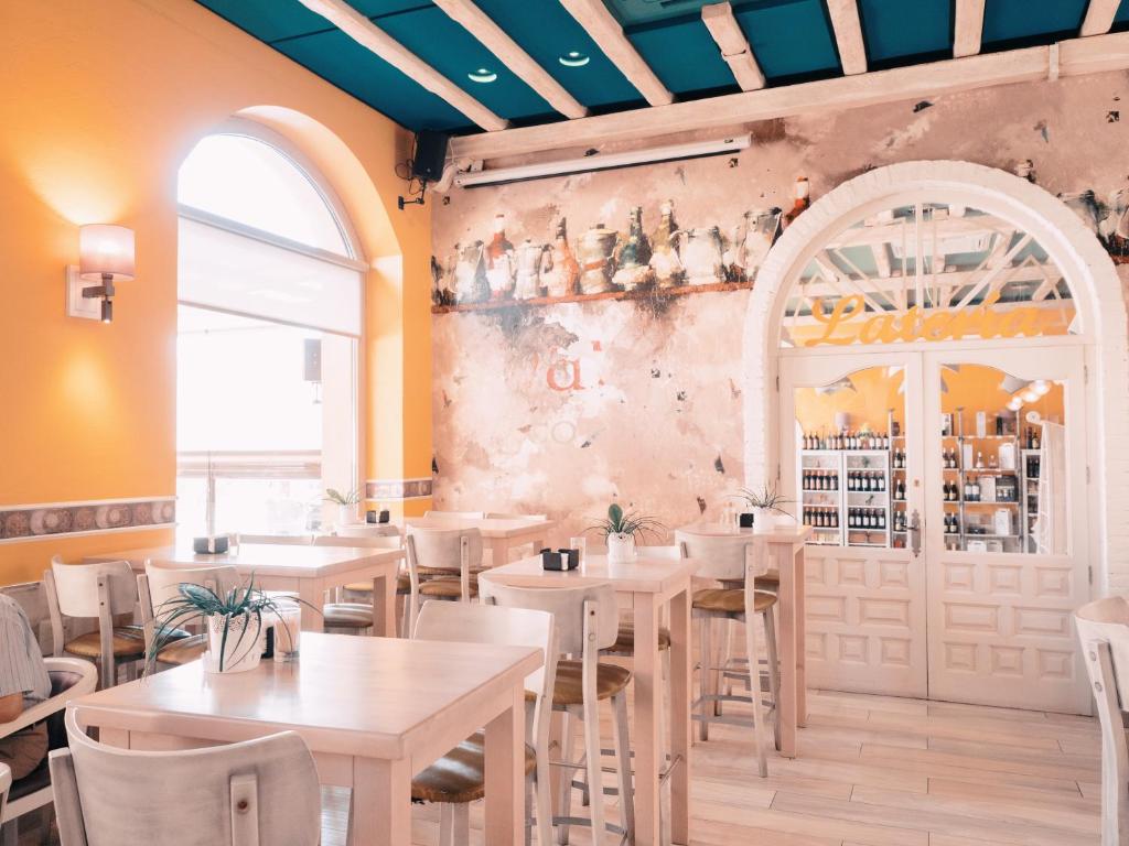 a restaurant with tables and chairs and a window at Hotel Los Toreros in Tordesillas