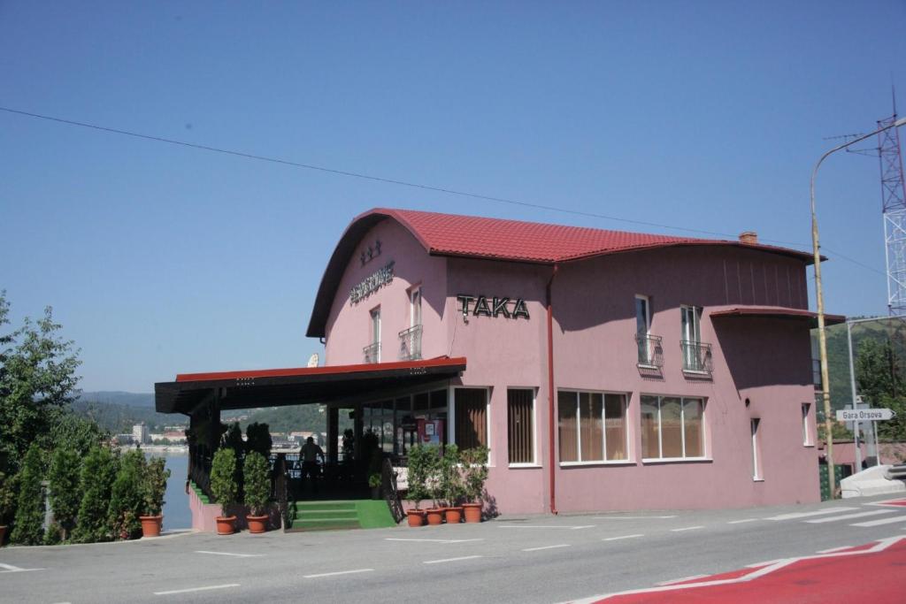 a pink building on the side of a street at Pensiunea Taka in Orşova