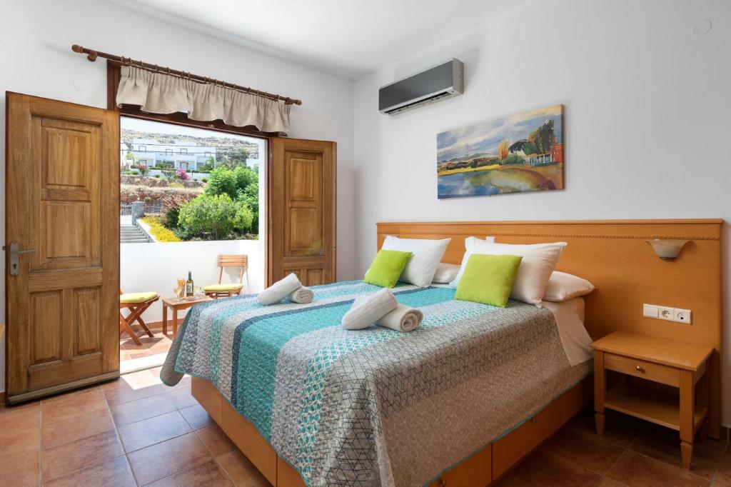 una camera da letto con un letto e una grande finestra di George's Villas a Líndos