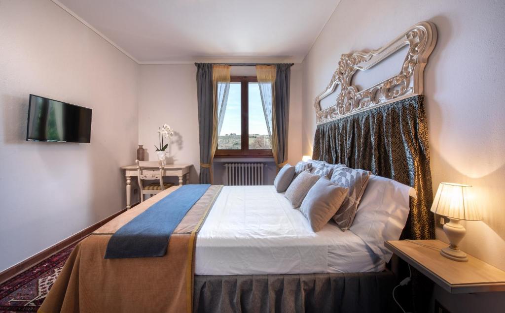 une chambre avec un grand lit avec une grande tête de lit dans l'établissement Agriturismo Casale Ugolini, à Montespertoli