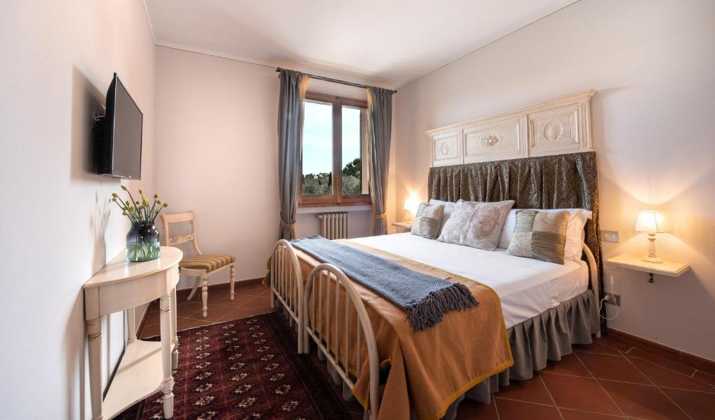 une chambre avec un lit et une télévision dans l'établissement Agriturismo Casale Ugolini, à Montespertoli