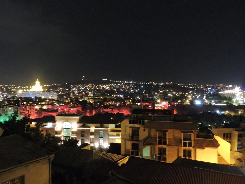 - une vue sur la ville la nuit avec des lumières dans l'établissement Apartment Panorama, à Tbilissi