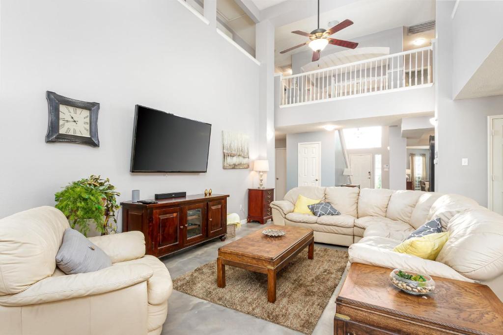 a living room with white furniture and a flat screen tv at Summer Deal! Symphony Home near Fort Worth Stock Rodeo, Globe Life, AT&T in Fort Worth