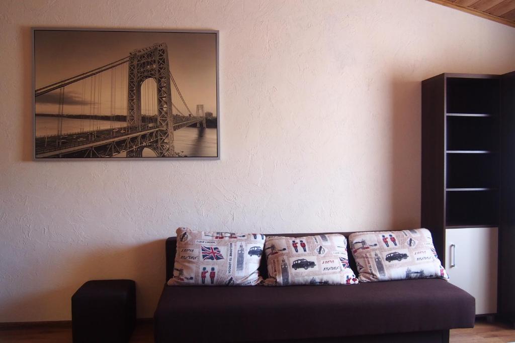 a couch with pillows and a picture of a bridge at Pokoje u Wojtka Charbrowo in Charbrowo