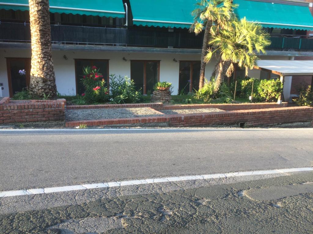 une rue vide en face d'un bâtiment planté de palmiers dans l'établissement AFFITTACAMERE SCIACCHETRA', à Deiva Marina