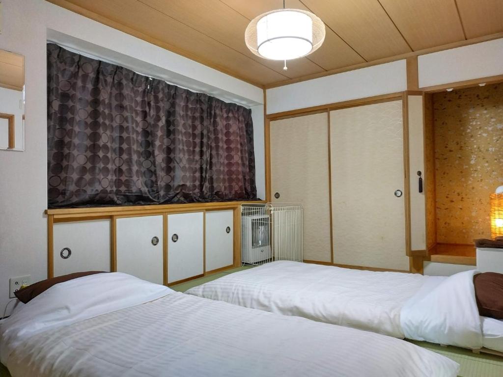 a bedroom with two beds and a window at Bay View House private room / Vacation STAY 3667 in Otaru