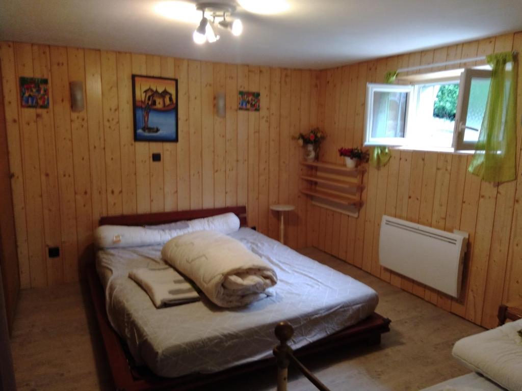 a bedroom with a bed in a room with wooden walls at luz saint sauveur doumet in Luz-Saint-Sauveur