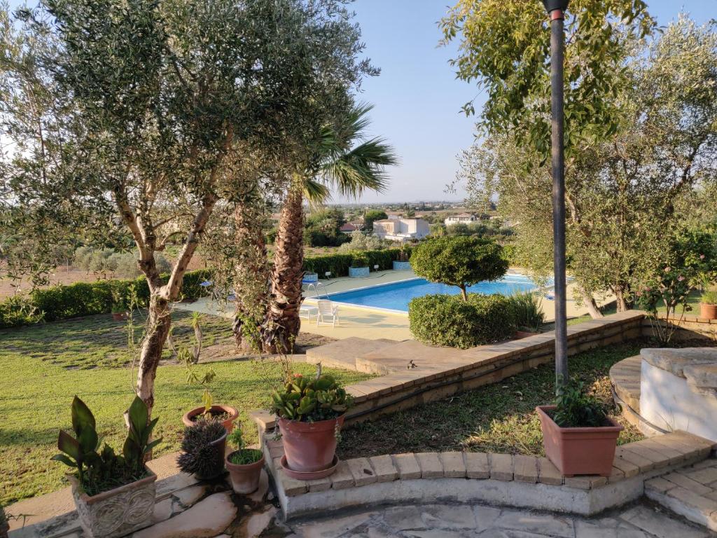 a garden with a swimming pool and some plants at Villa con piscina in Vittoria