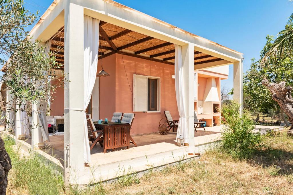 een paviljoen met een tafel en stoelen op een patio bij Villa Nanni in Gallipoli
