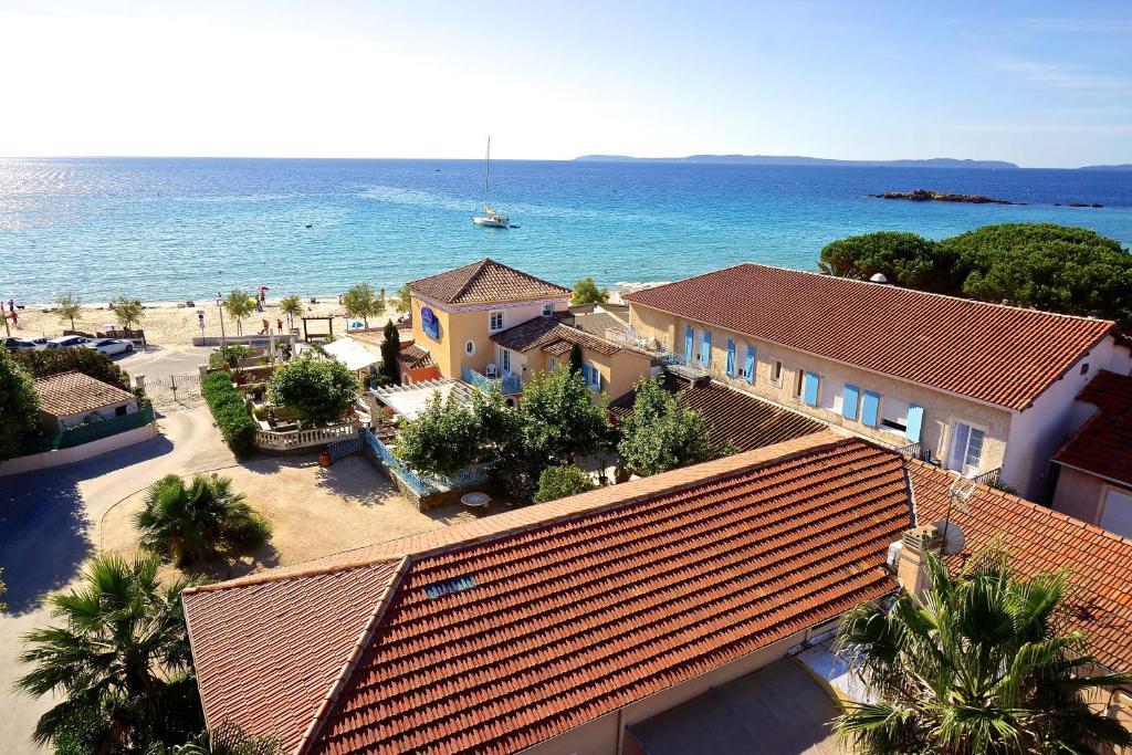 una vista aérea de una casa y del océano en Hotel Les Flots Bleus en Le Lavandou