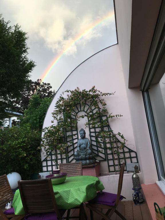 einen Regenbogen über einer Terrasse mit einem buddhistischen Wandbild in der Unterkunft Reiser in Épernay