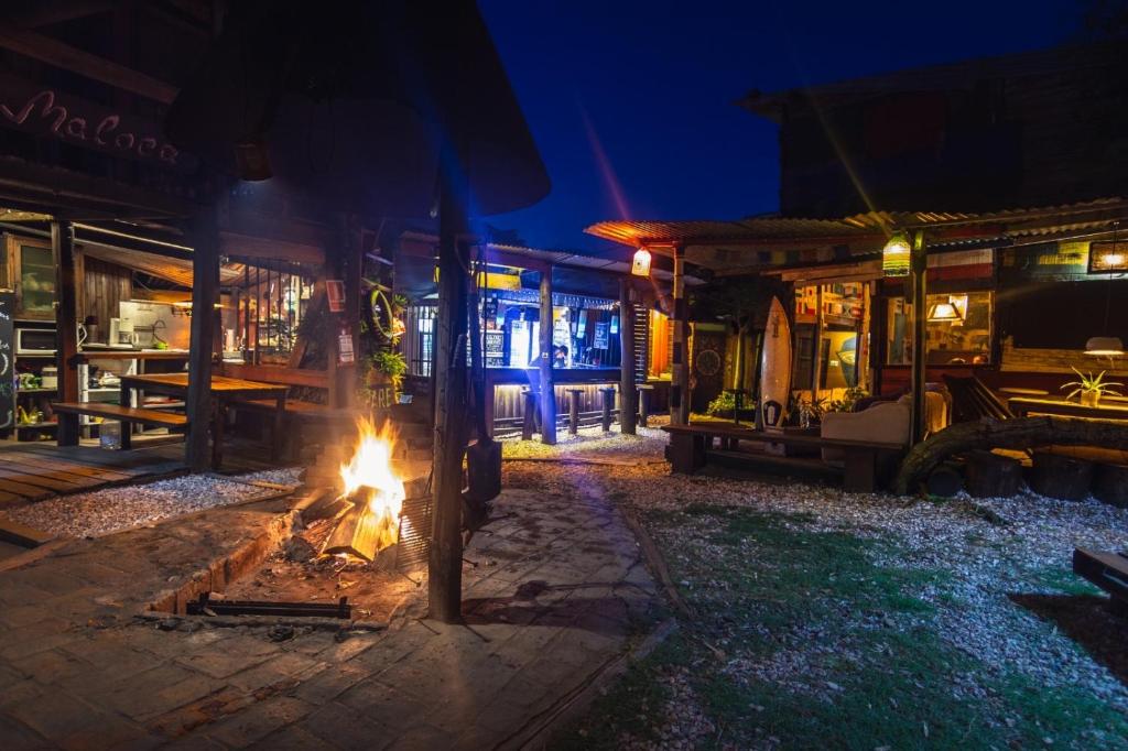 a fire pit in front of a restaurant at night at La Brújula Hostel in La Paloma
