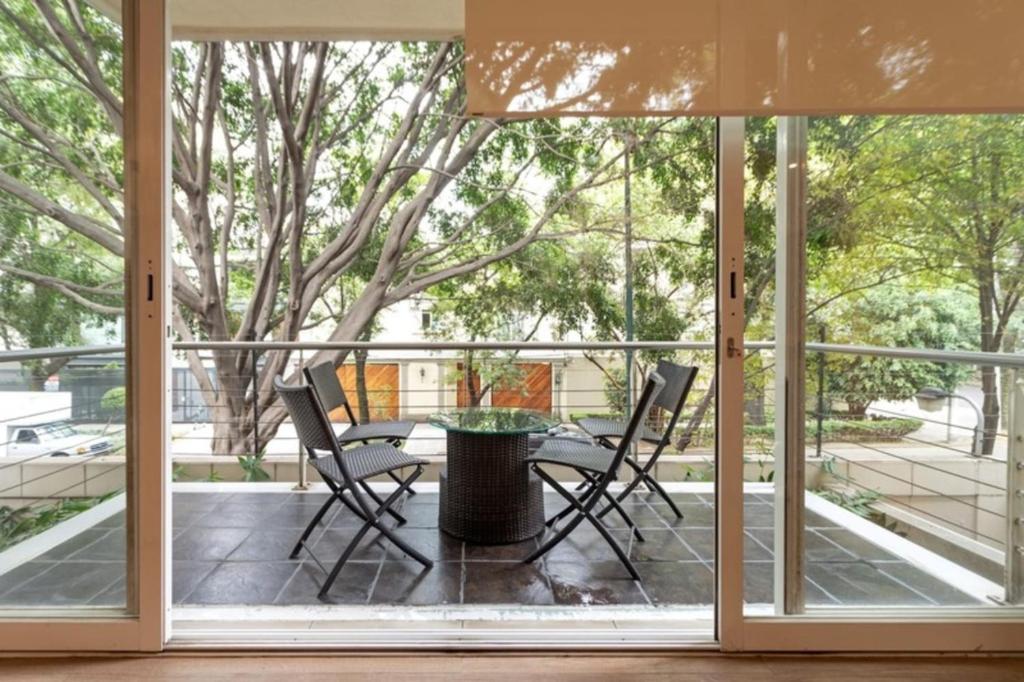 a screened in porch with two chairs and a table at Mi Casa # 4 En la Zona Mas Exclusiva de Polanco in Mexico City