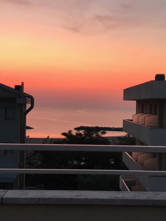 uma vista para o pôr-do-sol a partir da varanda de um edifício em Attico Belvedere em Lido di Classe